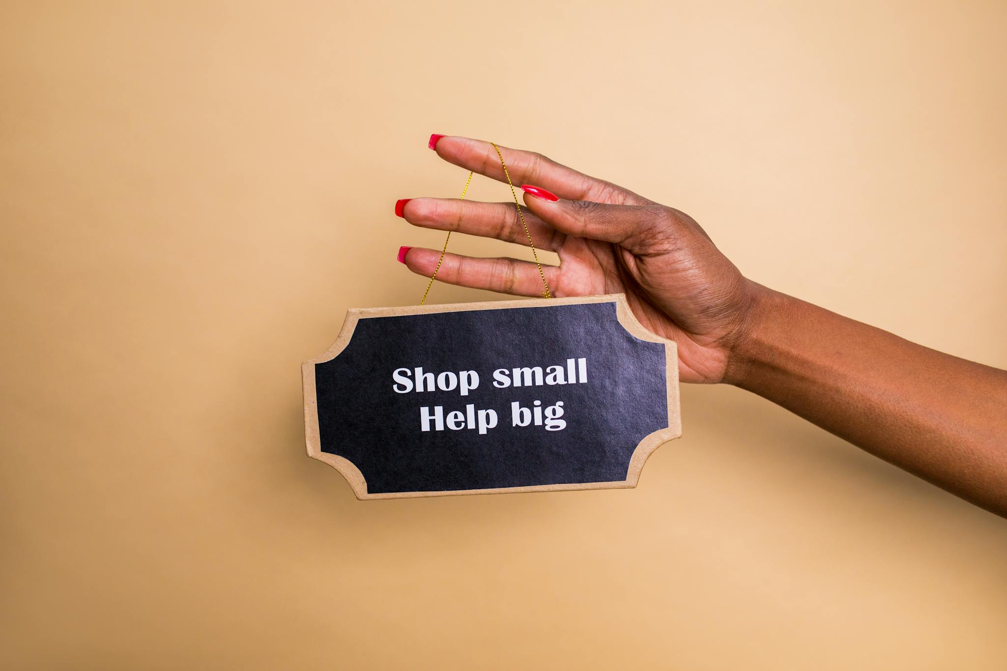 close up of a hand holding an inspiring sign encouraging small businesses support. 7563663