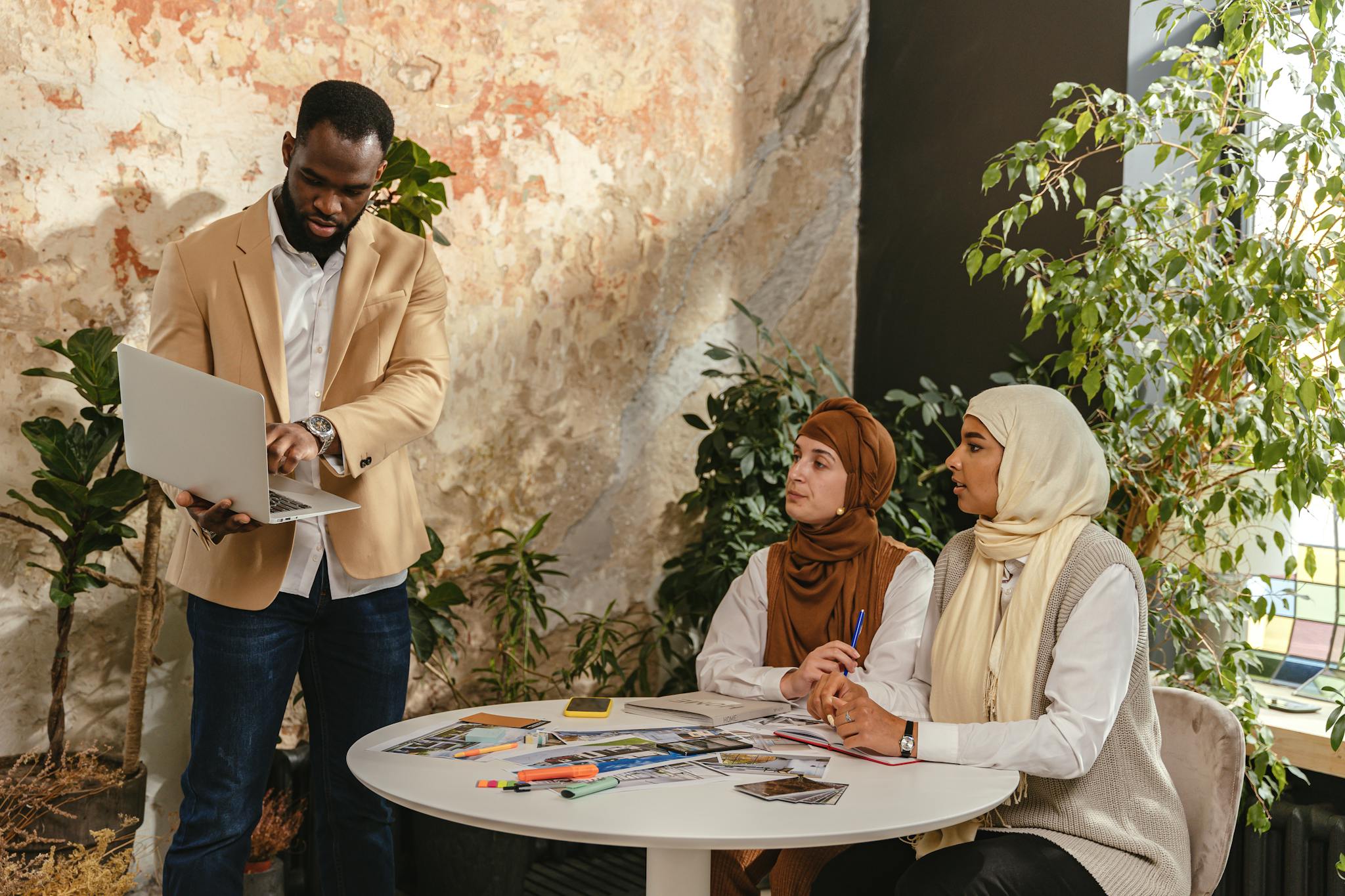 professional business team in meeting with laptops papers and diverse attire collaborating indoors. 8837600